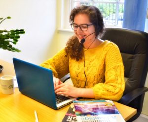 Student sitting in front of laptop taking part in online language lessons