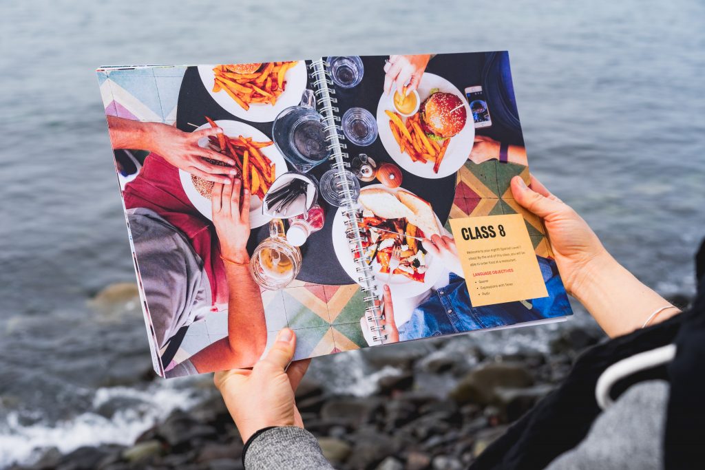 A languages book, pages open to show a selection of delicious food. We propose that language training is a great way to enhance sales team motivation.